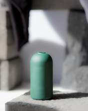 Load image into Gallery viewer, With it's clean lines and sleek shape, this minimalistic and elegant hand blown vase gives a unique touch to your décor with it's deep forest green finish. A playful twist on a timeless piece that will elevate your Everlasting Candles. Product Highlights Custom design Handblown glass Statement piece